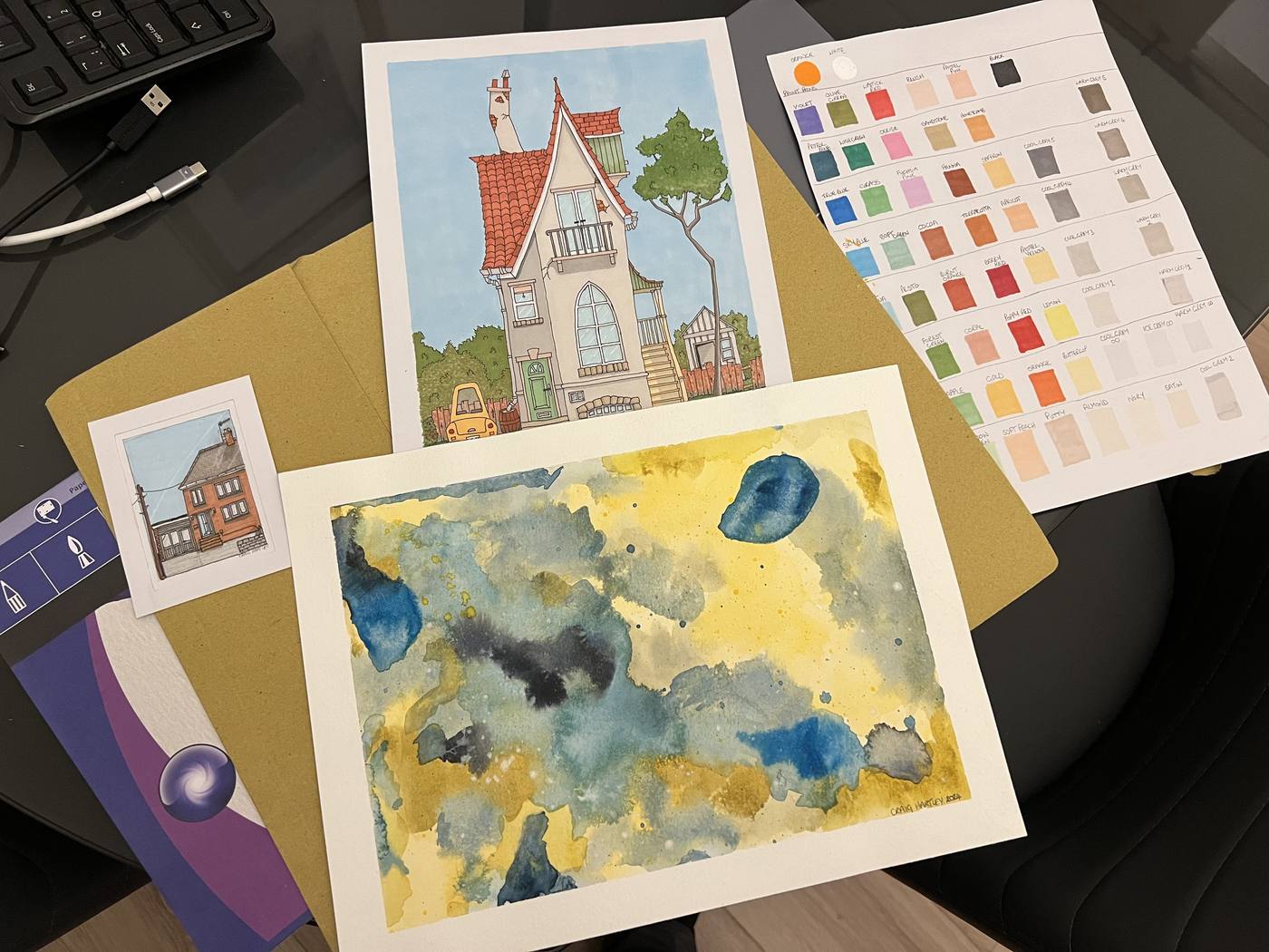 Desk shot of a house painting alongside a colour palette