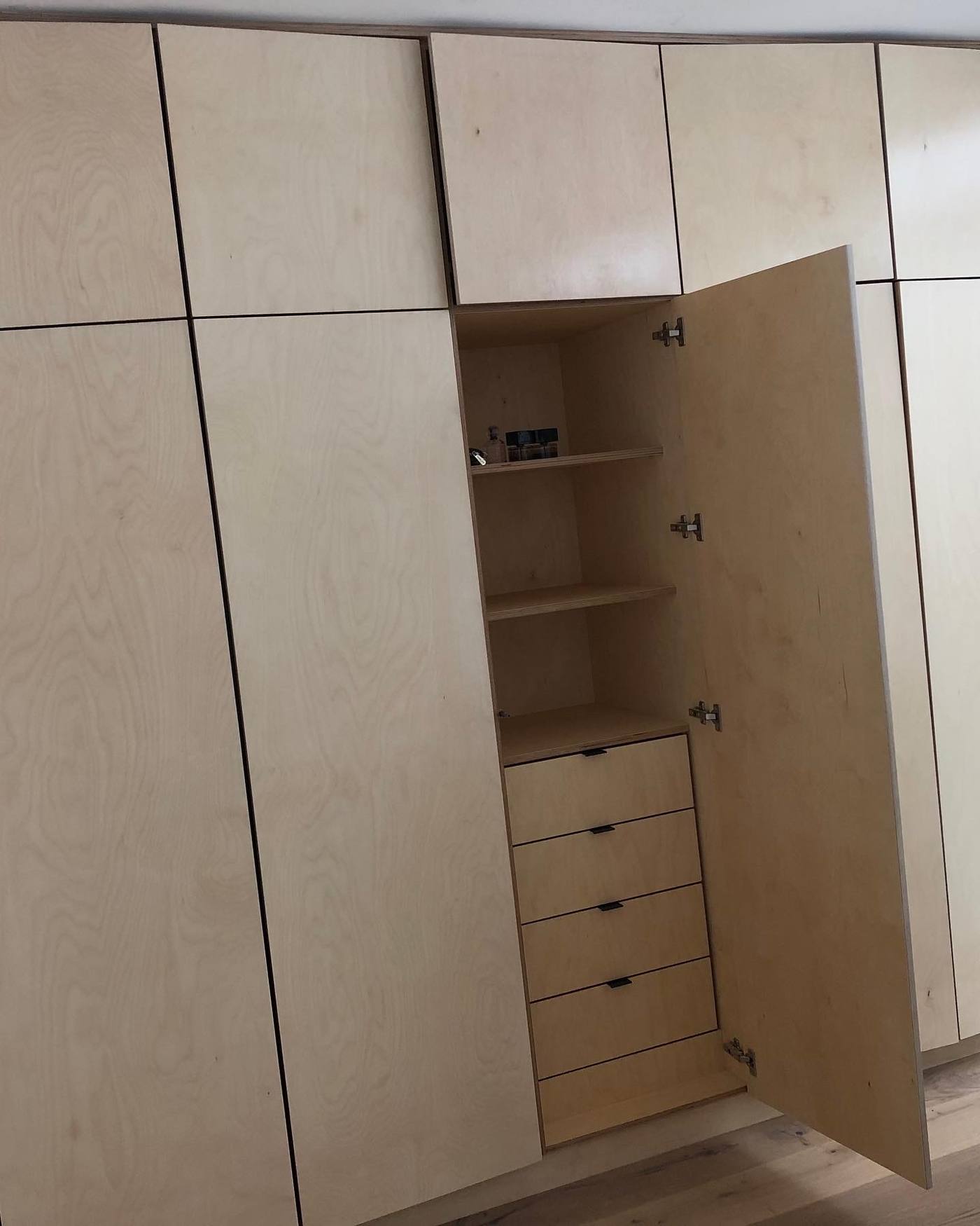 Fitted plywood wardrobe with door open