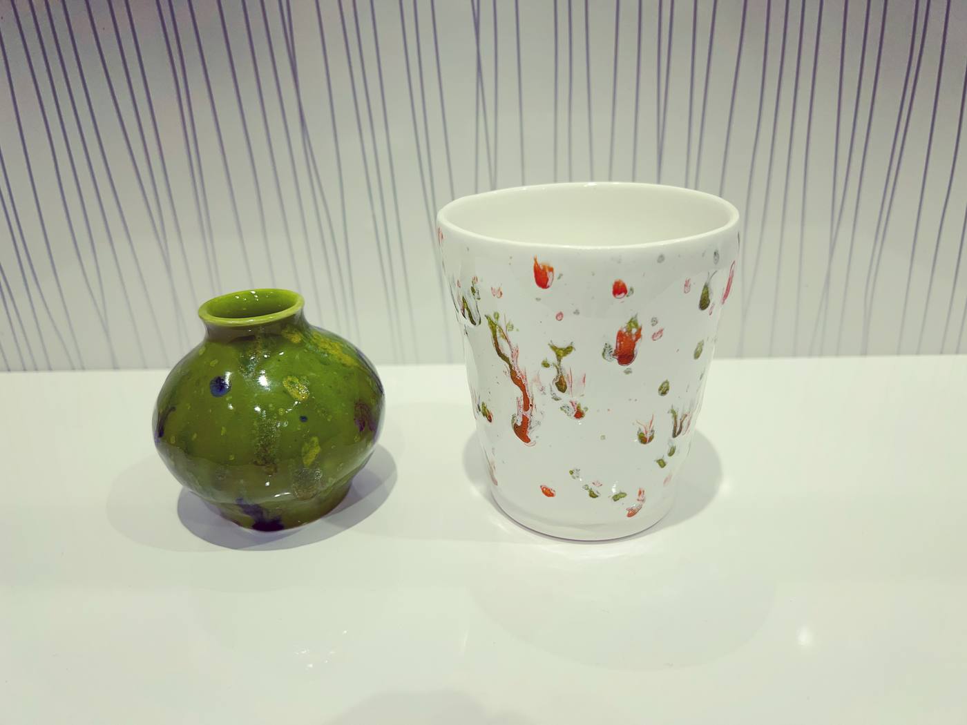Green vase and speckled white cup