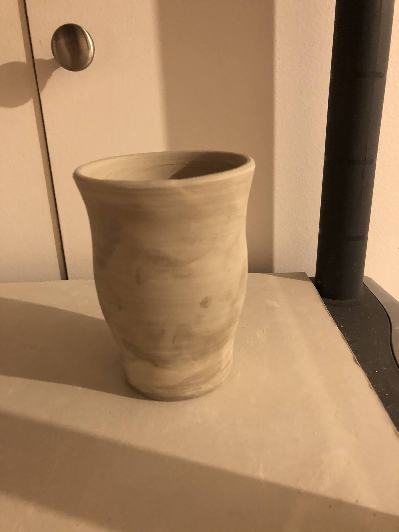 Unglazed vase on a cabinet